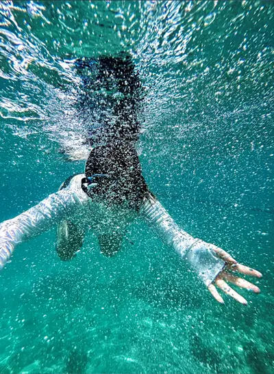 a person swimming underwater with bubbles