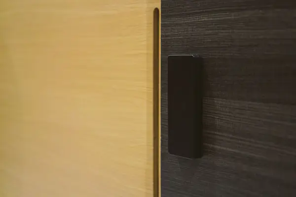 a black rectangular object on a wooden surface