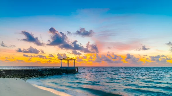 a beach with a gazebo and a body of water